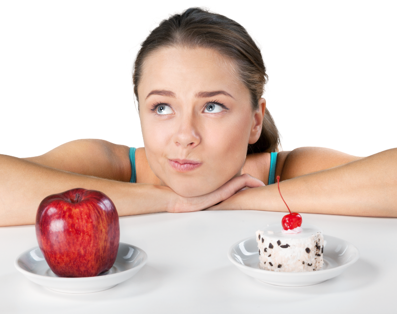 Jeune femme qui hésite à manger une pomme ou un gâteau pour réussir son rééquilibrage alimentaire